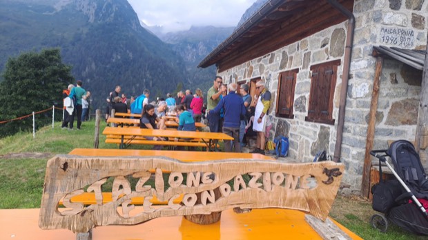 Le tavolate davanti alla malga, con l'insegna della Stazione di Fecondazione in primo piano